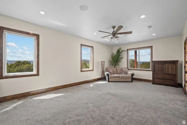 Living area with carpet floors, a ceiling fan, and recessed lighting