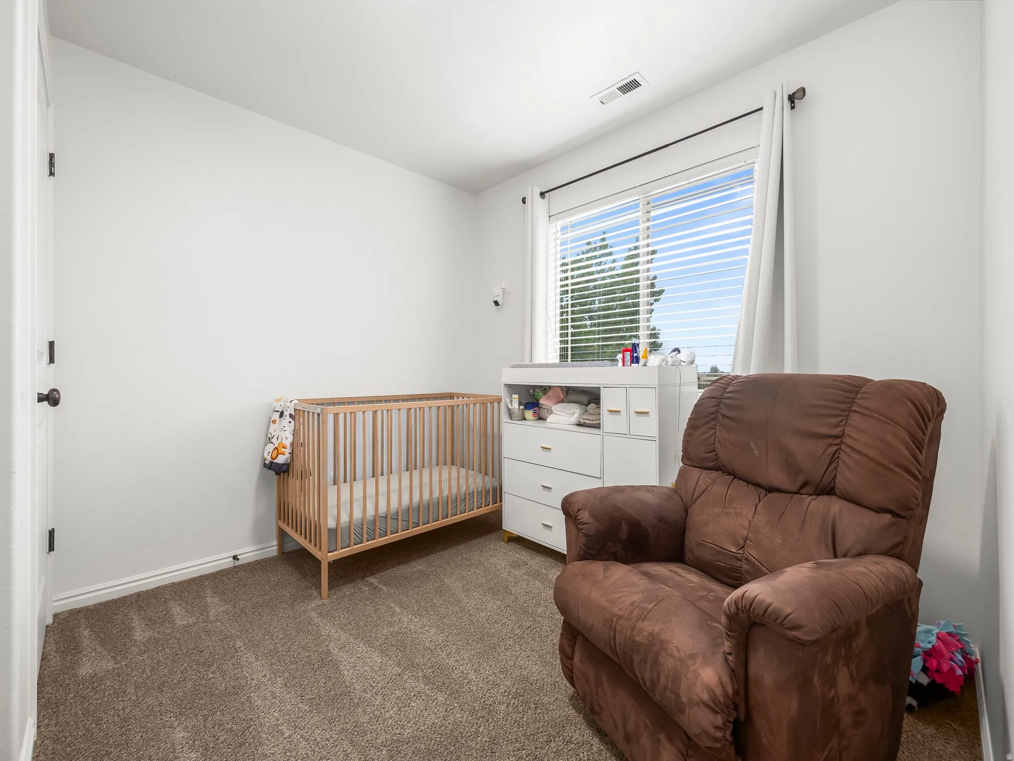 Room with neutral wall paint, textured carpeting, and a window with blinds