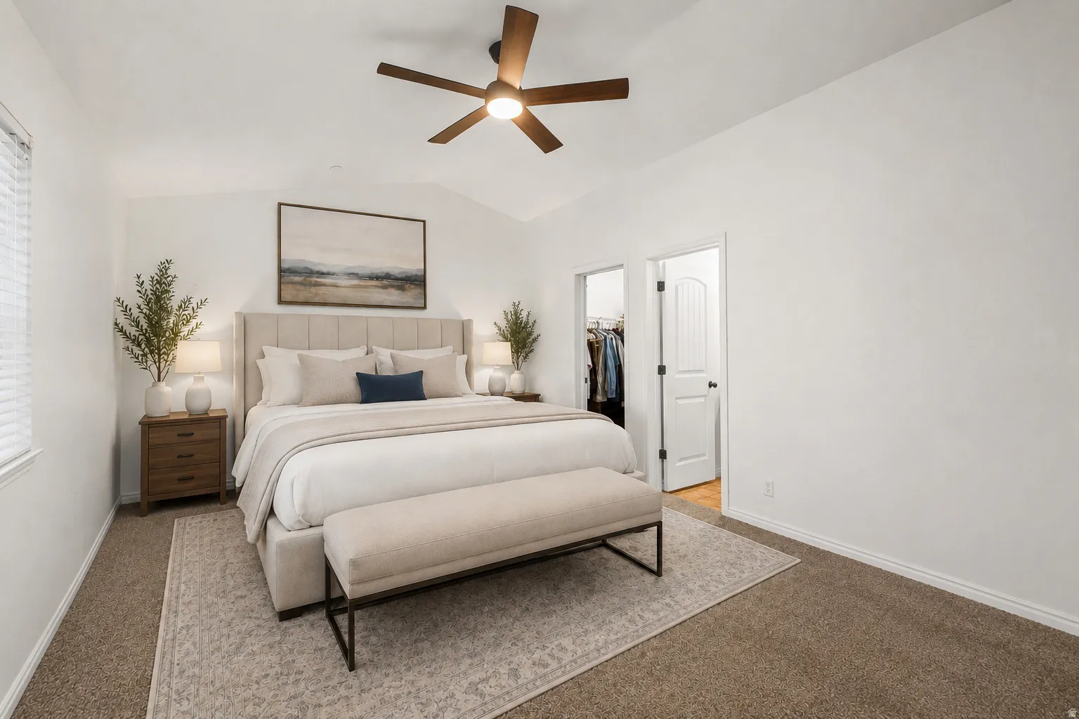 Primary bedroom featuring a wood-finish ceiling fan with integrated lighting, neutral upholstered headboard, wood-finish nightstands, and neutral area rug anchoring the space