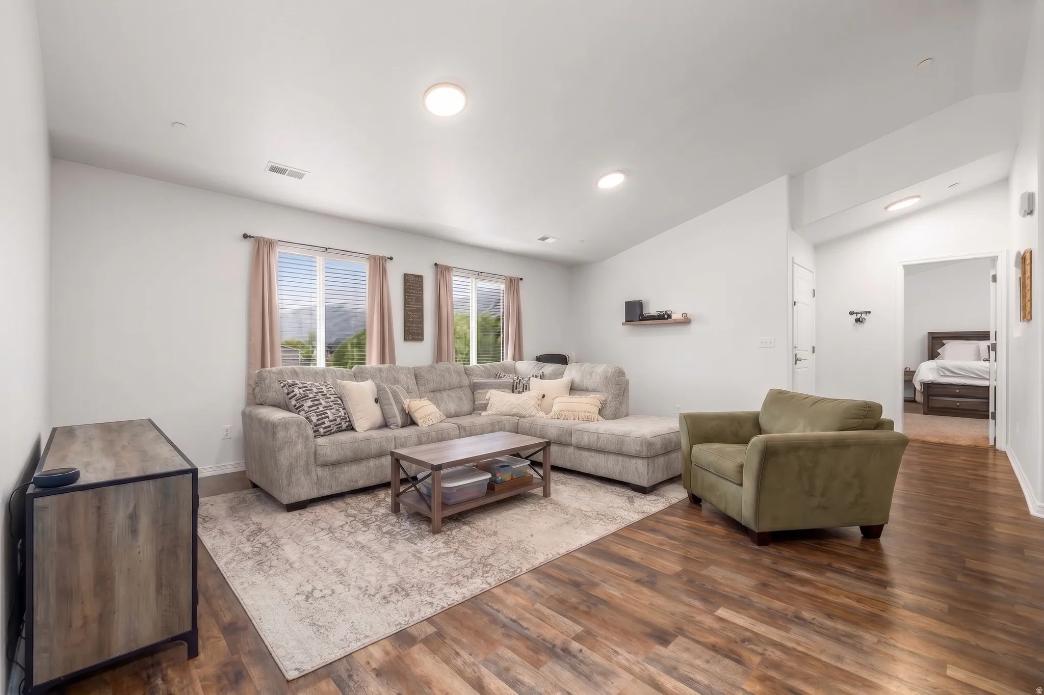 Vaulted ceiling, recessed lighting, wood-finish flooring, multiple windows, built-in shelving