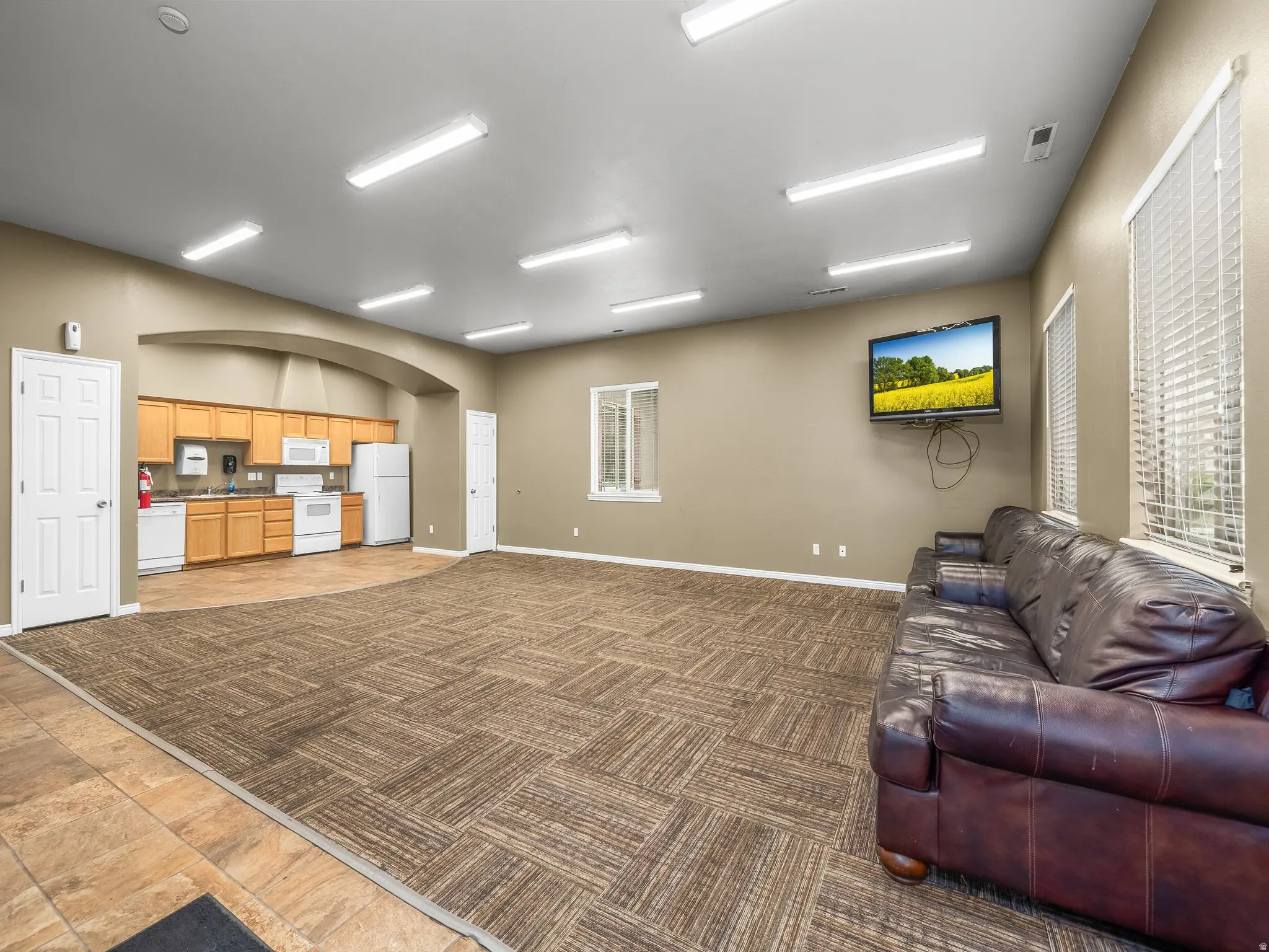 Living area with light colored carpet and arched walkways