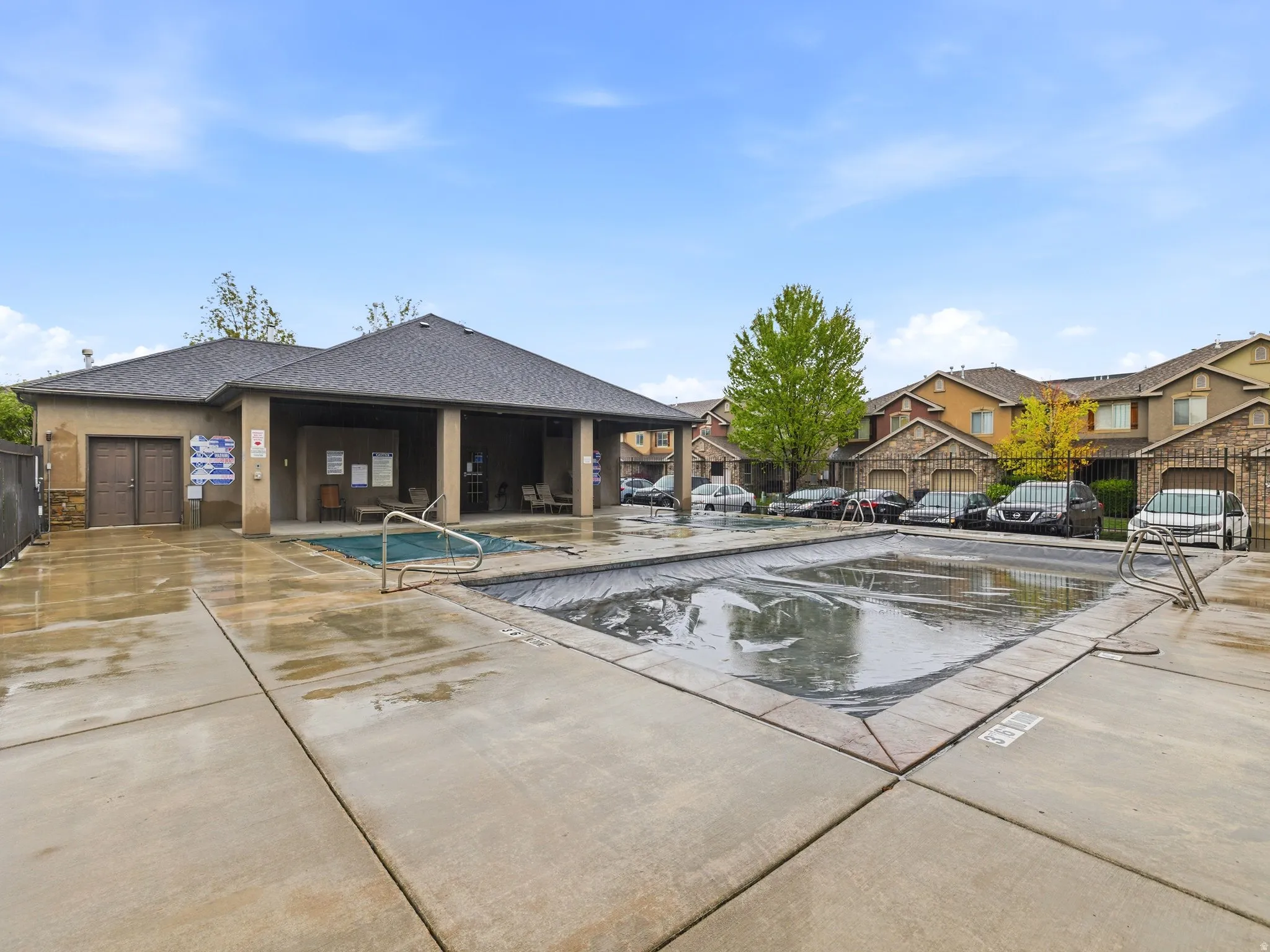 Community pool with a patio area and a residential view