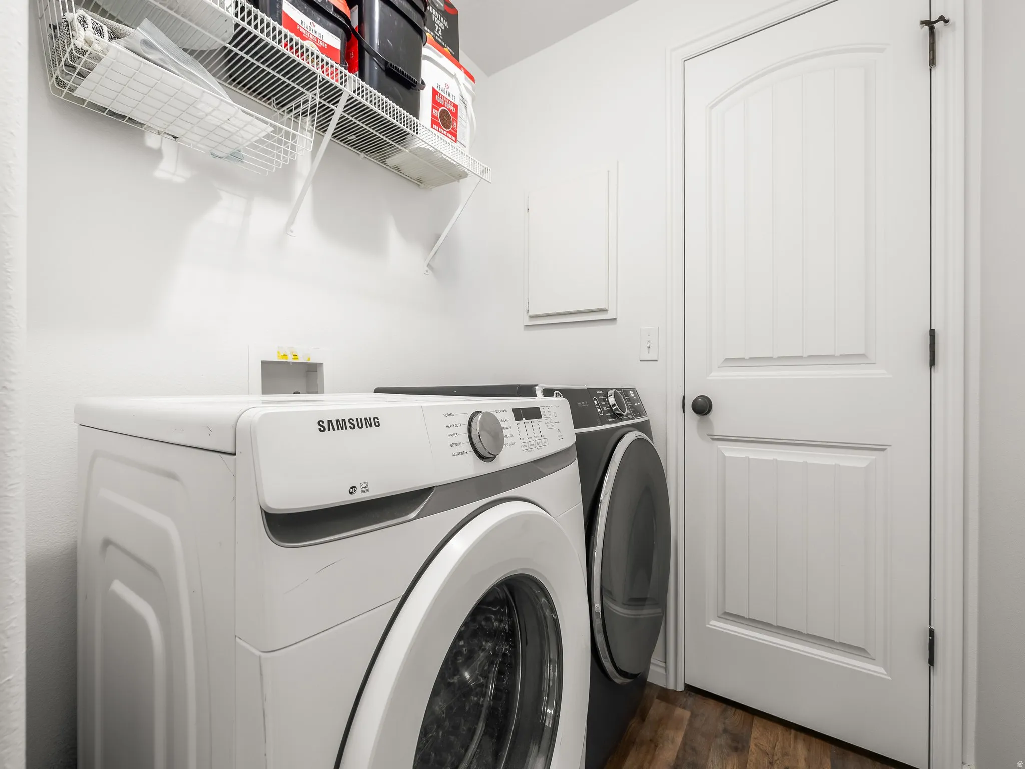 Laundry area featuring dark wood-type flooring and utility room access.
