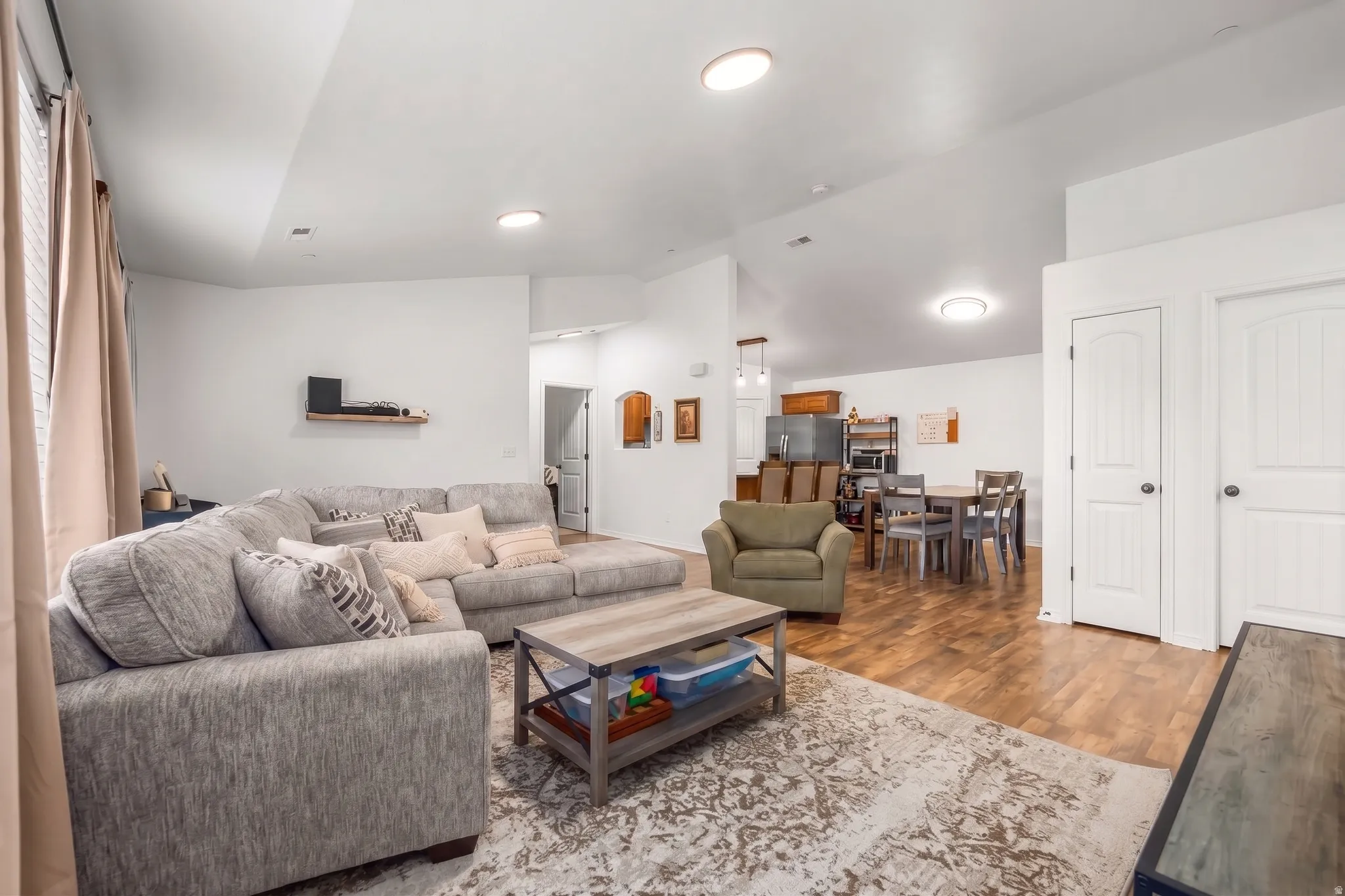 Open-concept living area with wood-finish flooring, recessed lighting, and white interior doors