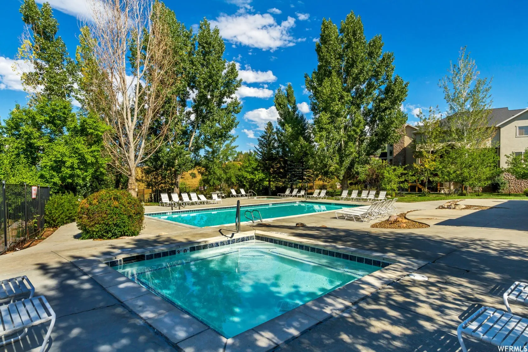 Community pool featuring a patio and a hot tub