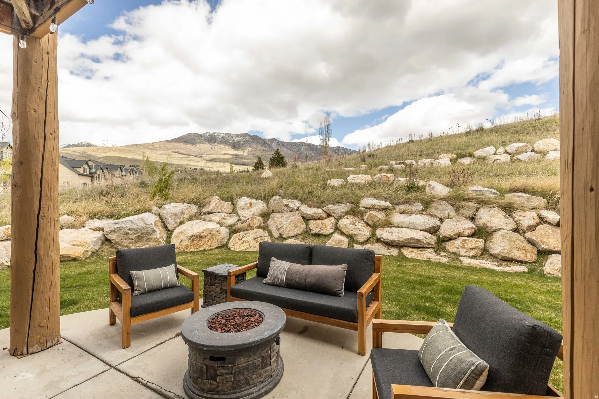 View of patio with a mountain view and an outdoor living space with a fire pit