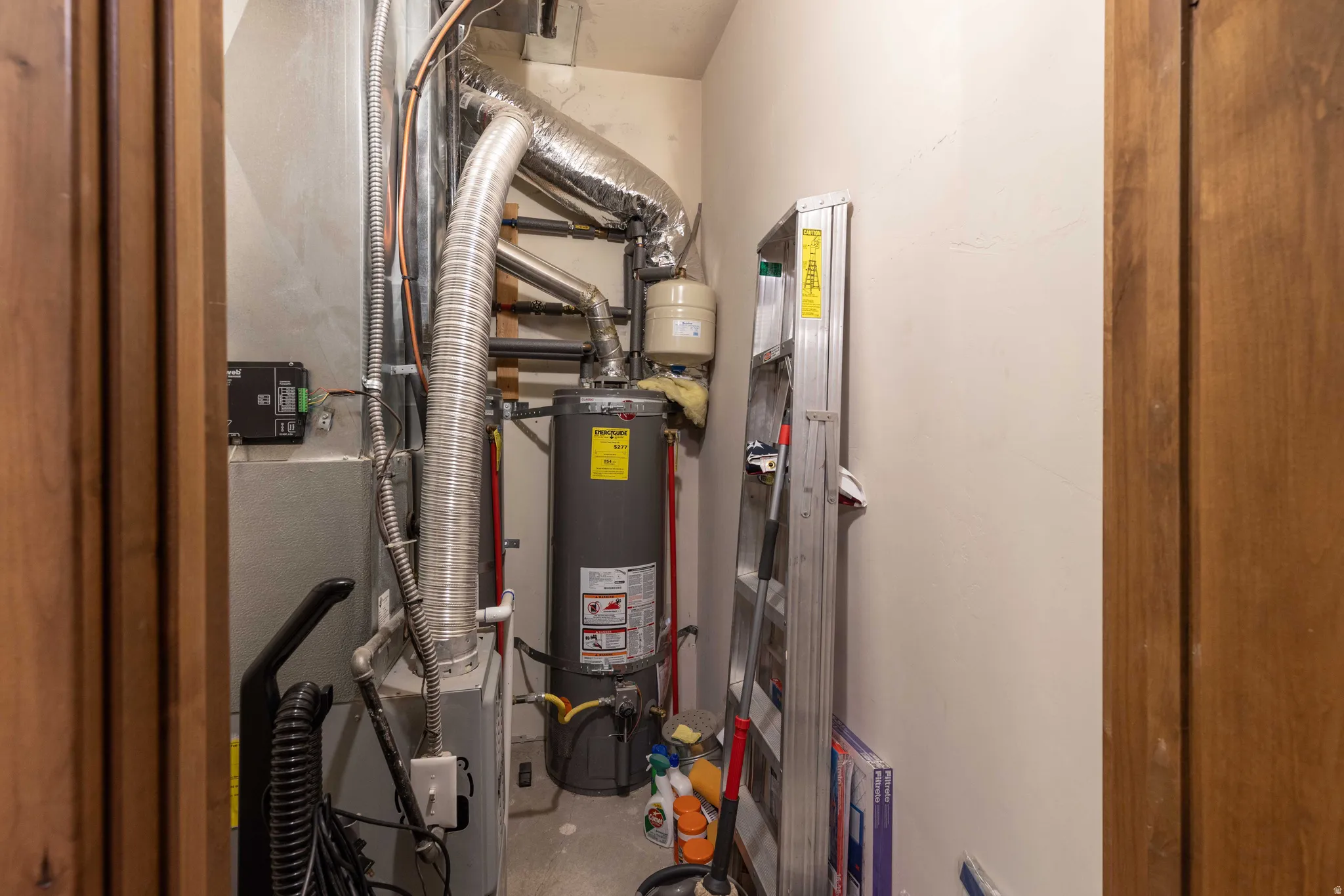 Utility room featuring heating unit and water heater