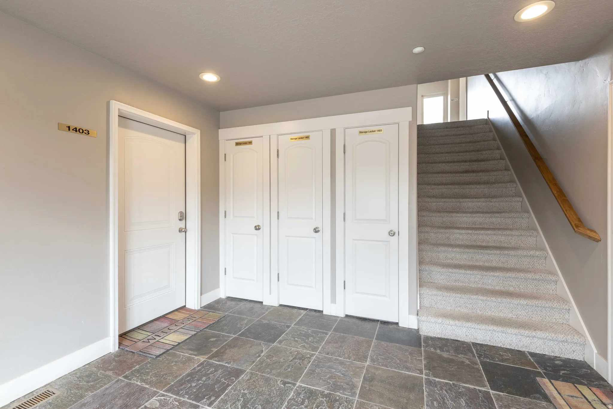 Staircase with recessed lighting and stone tile floors