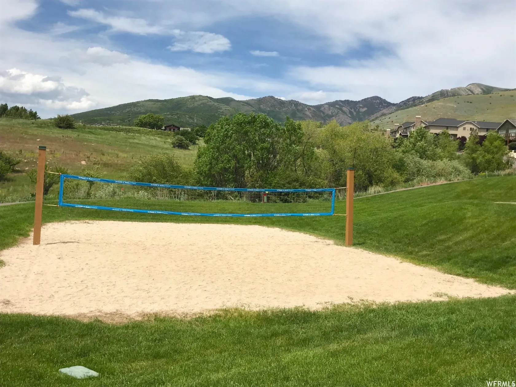 View of community with a mountain view, volleyball court, and a rural view