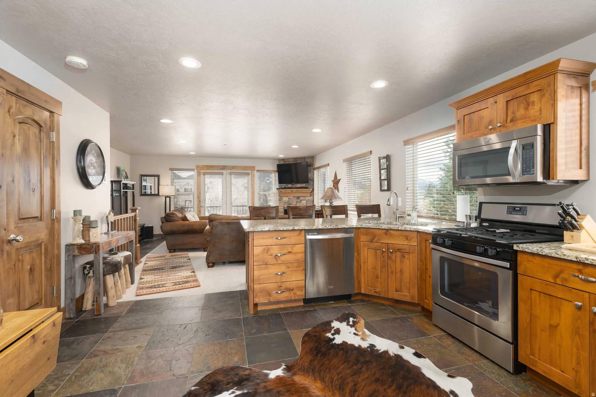 Kitchen with a peninsula, stainless steel appliances, open floor plan, wood finish cabinets, and recessed lighting