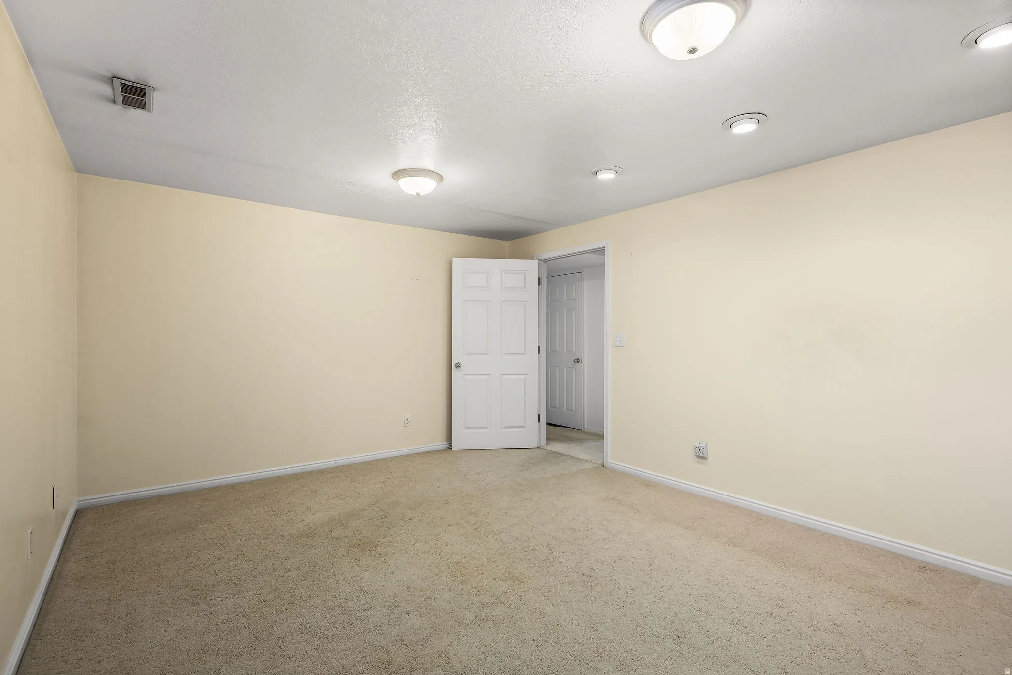 Unfurnished room featuring light colored carpet and baseboards