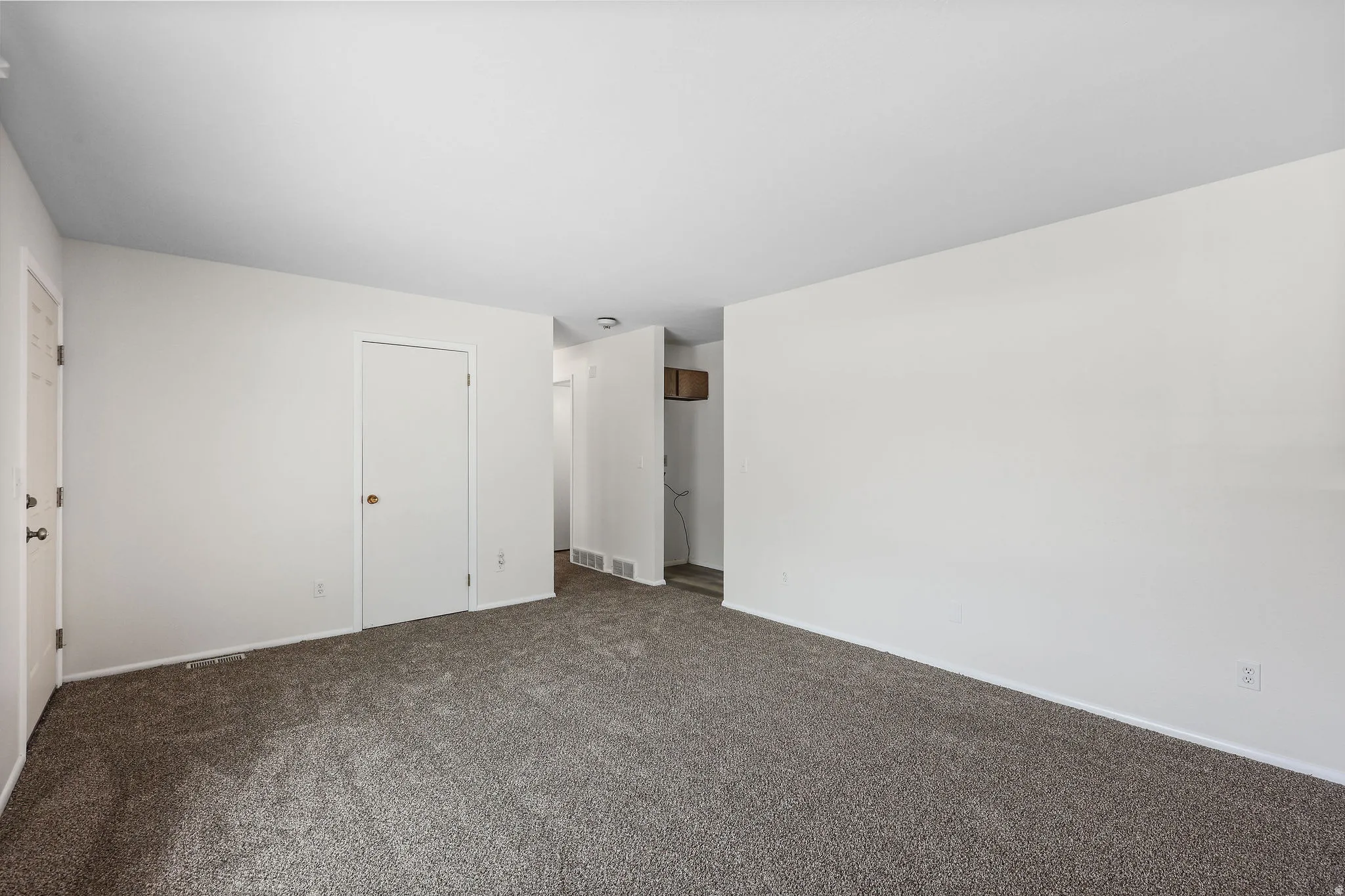Unfurnished bedroom with dark colored carpet and baseboards