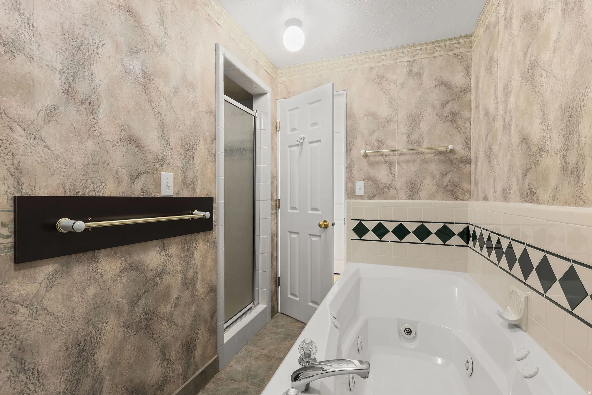 Full bath featuring a stall shower and a whirlpool tub
