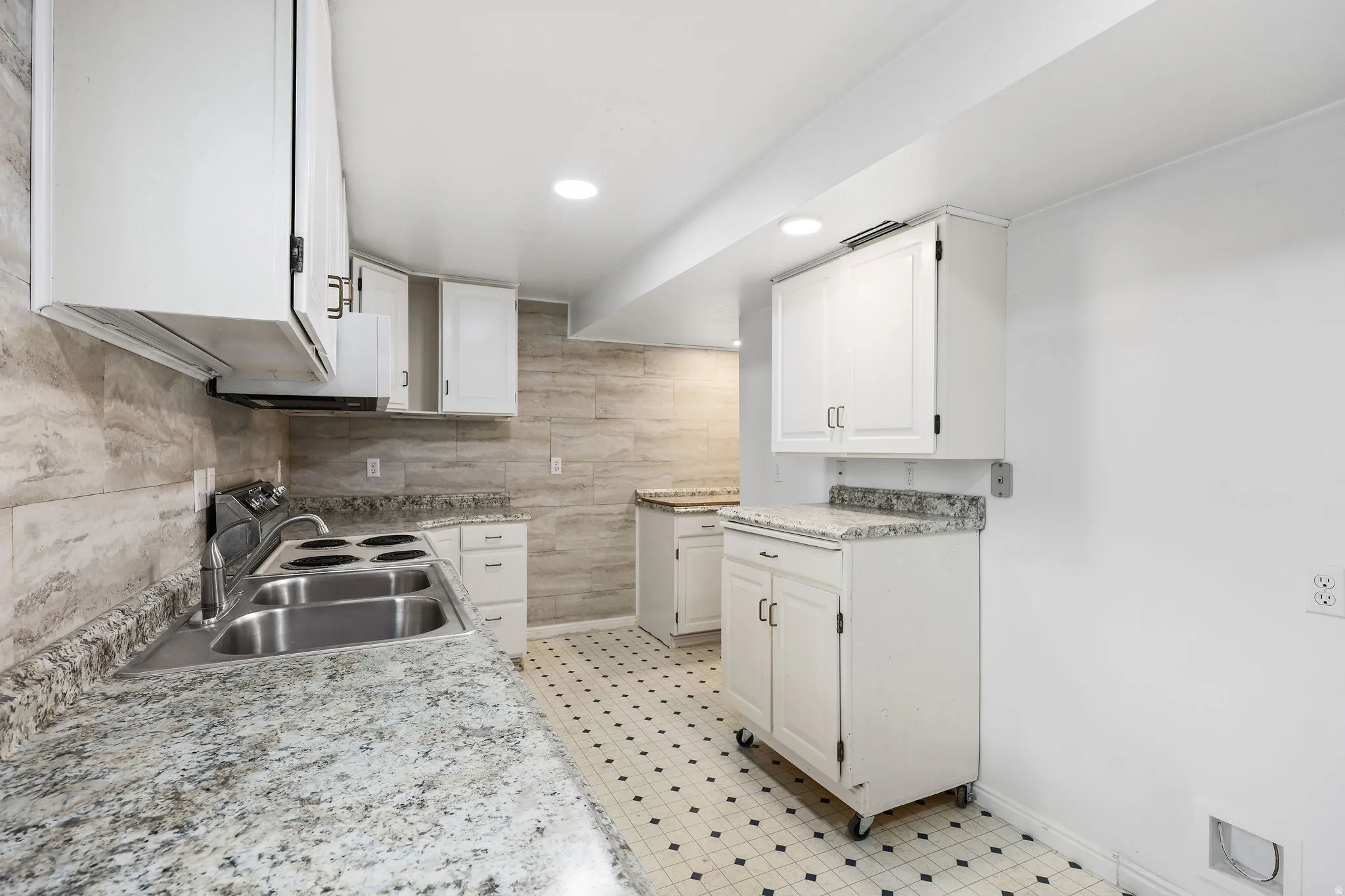 Kitchen with white cabinetry, light countertops, light floors, and recessed lighting