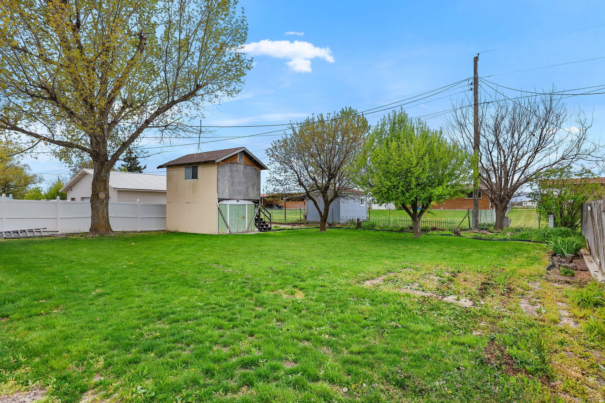 Fenced backyard featuring an outbuilding