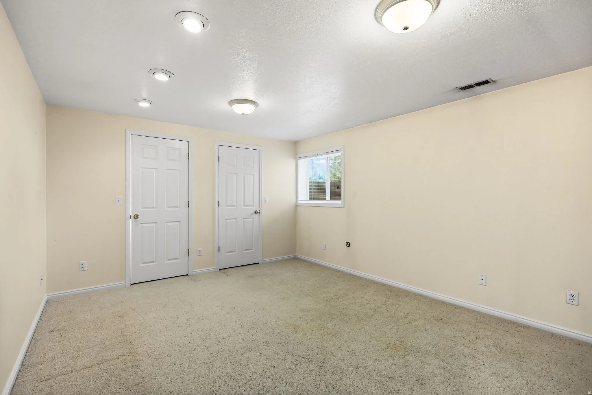 Unfurnished bedroom featuring light colored carpet and baseboards