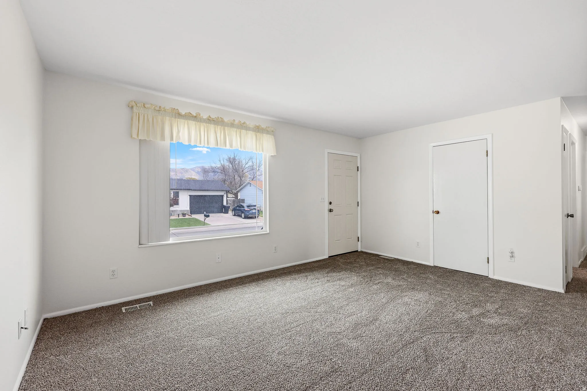 Carpeted spare room featuring baseboards