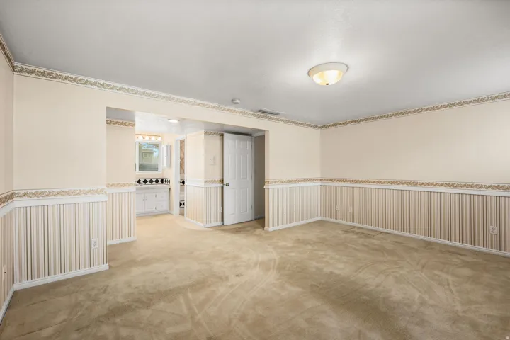 Spare room with wainscoting and light carpet