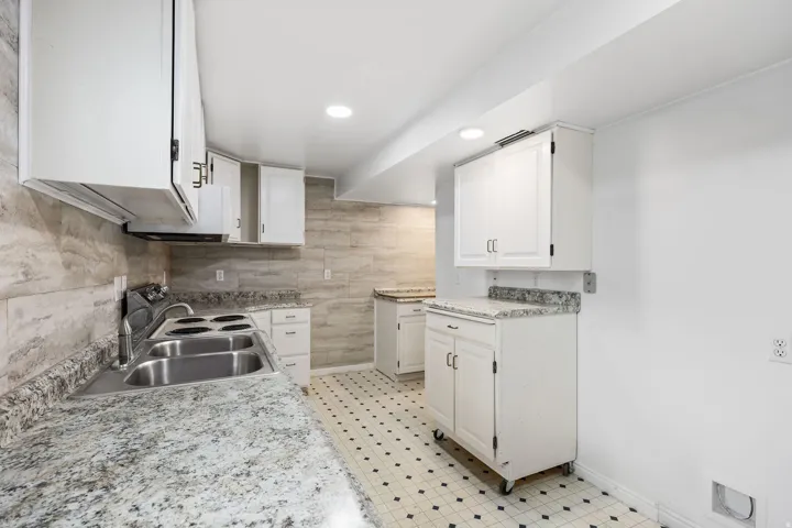 Kitchen with white cabinetry, light countertops, light floors, and recessed lighting