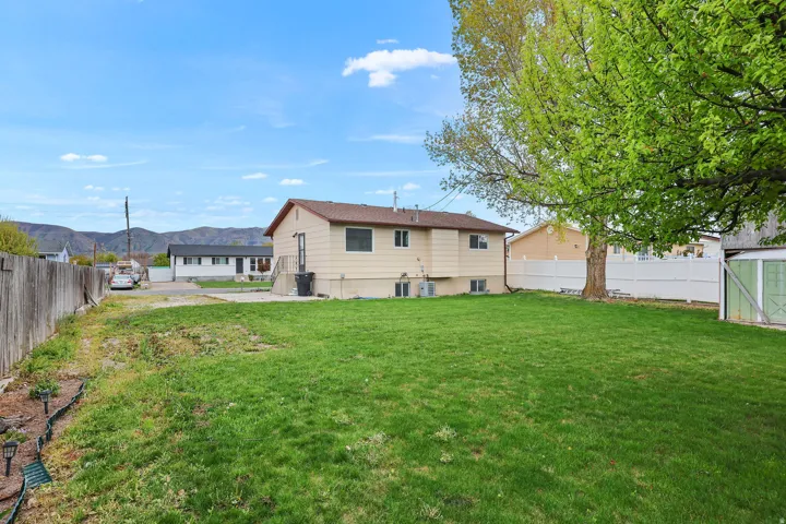 Rear view of property with a fenced backyard and a mountain view