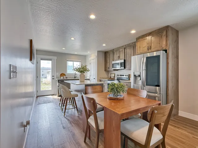 Dining space featuring light wood-style floors, a textured ceiling, and recessed lighting