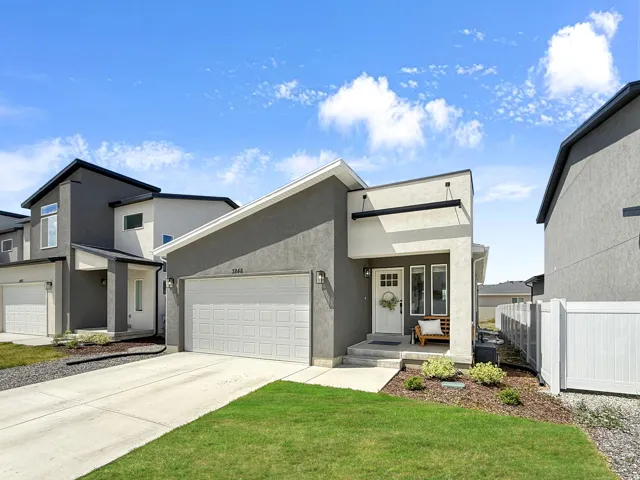 Contemporary house with a garage, driveway, and stucco siding
