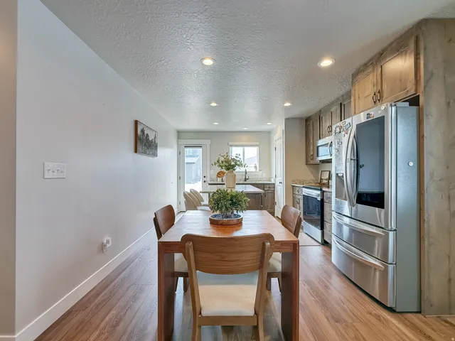 Dining area featuring a textured ceiling, light wood-type flooring, and recessed lighting