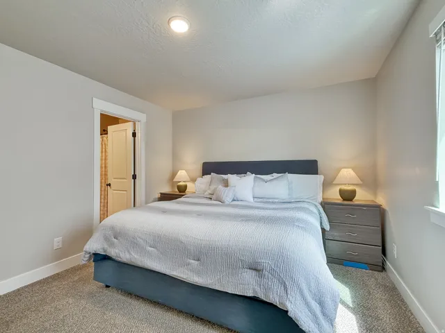 Carpeted bedroom featuring baseboards and a textured ceiling