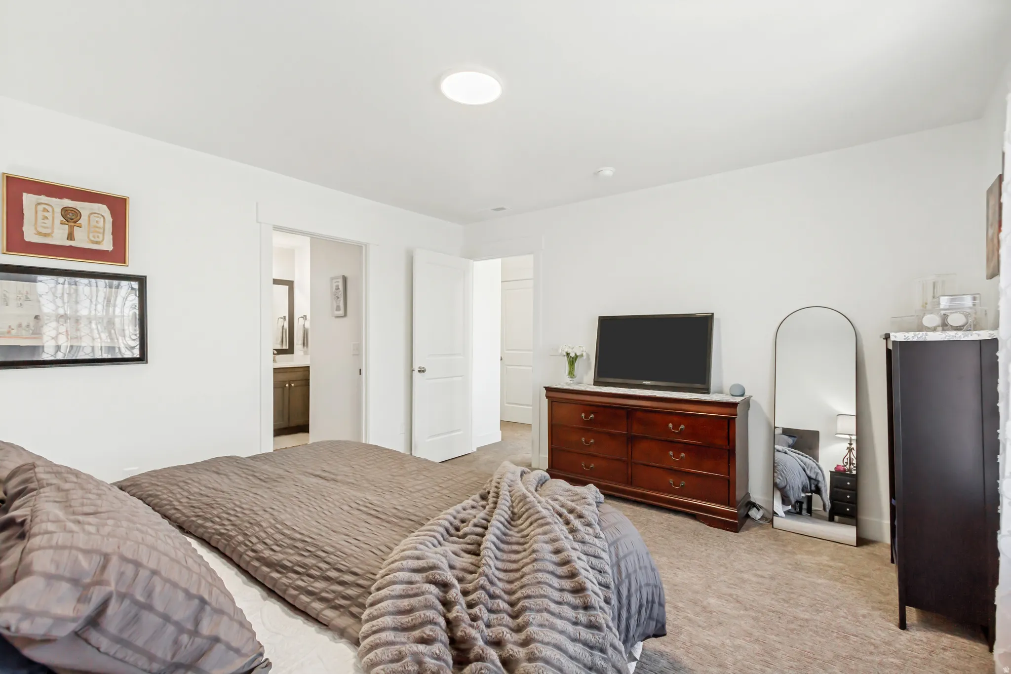 Owners bedroom with light carpet and ensuite bathroom.