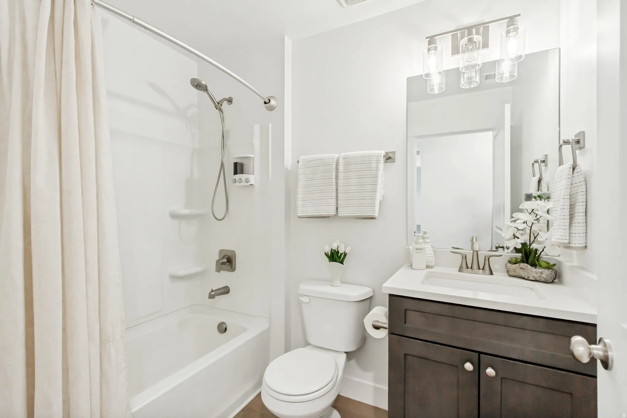 Bathroom featuring vanity and shower / bath combination with curtain.