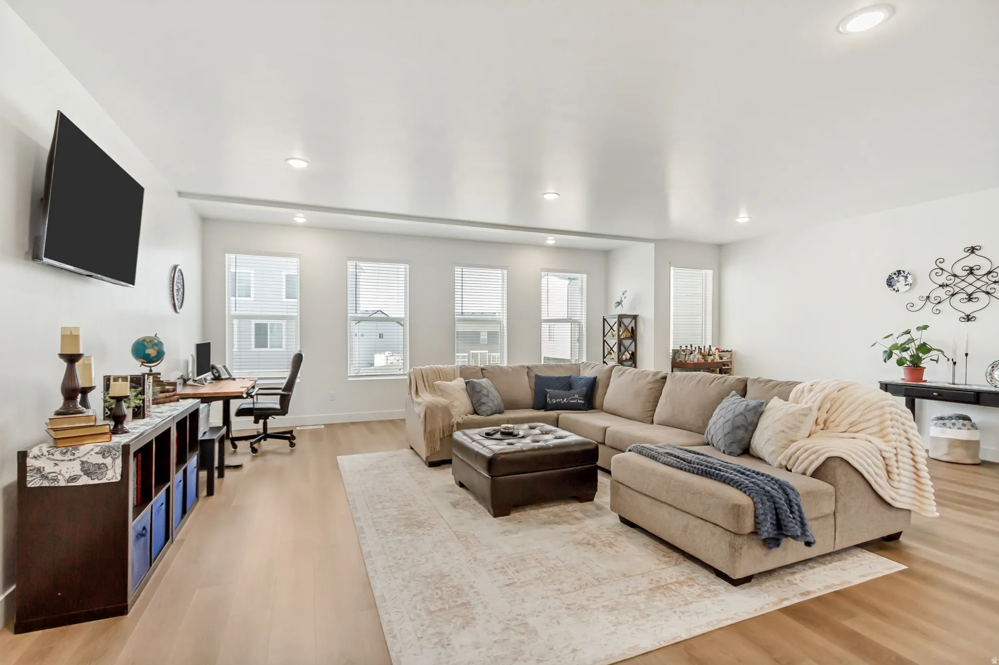 Living area featuring a desk, light wood finished floors, and recessed lighting.
