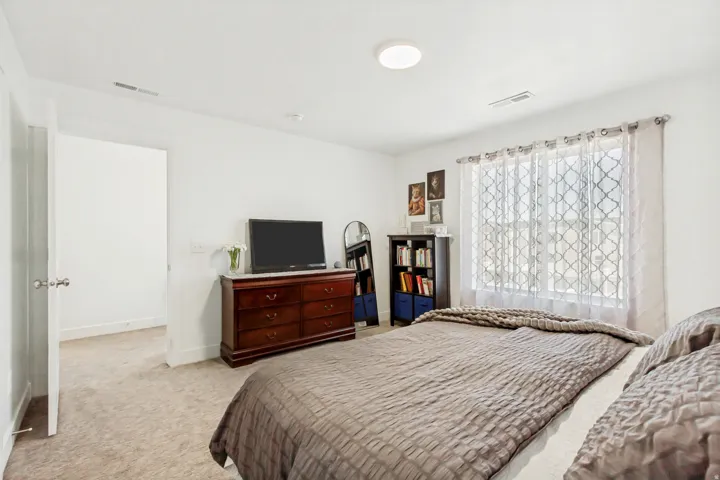 Owners bedroom featuring light carpet and baseboards.