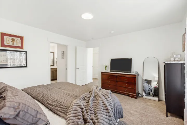 Owners bedroom with light carpet and ensuite bathroom.
