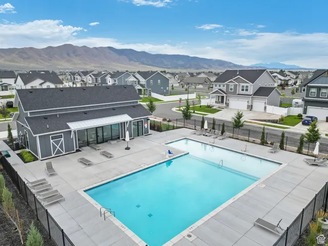Community pool featuring a patio, a mountain view, and a residential view