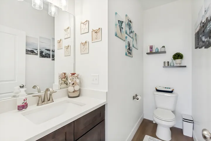 Half bathroom with vanity and wood finished floors.