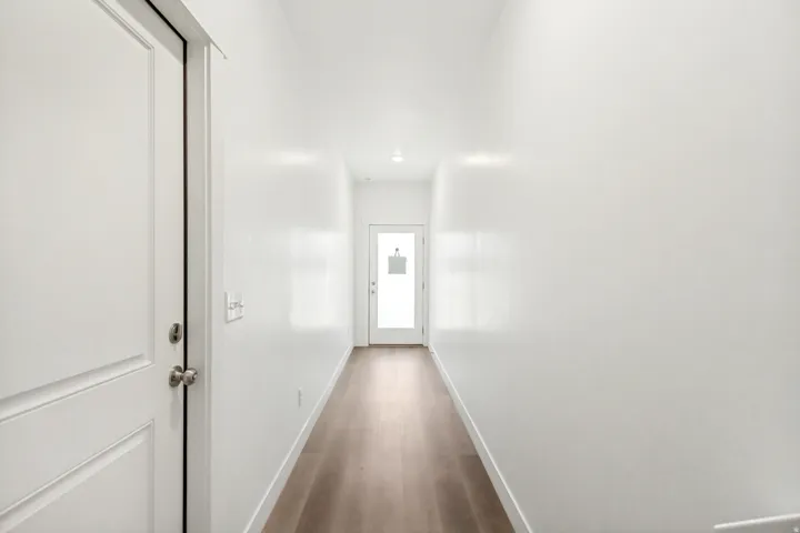 Corridor featuring wood finished floors and baseboards.