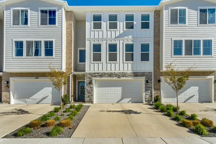 View of front facade with driveway and a garage.