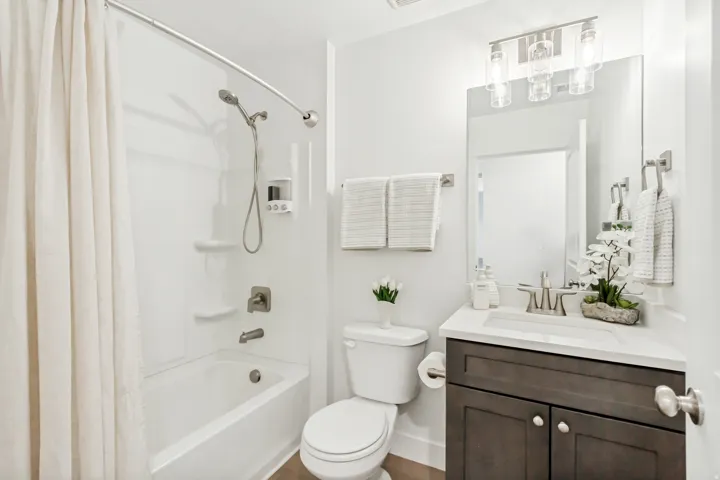 Bathroom featuring vanity and shower / bath combination with curtain.