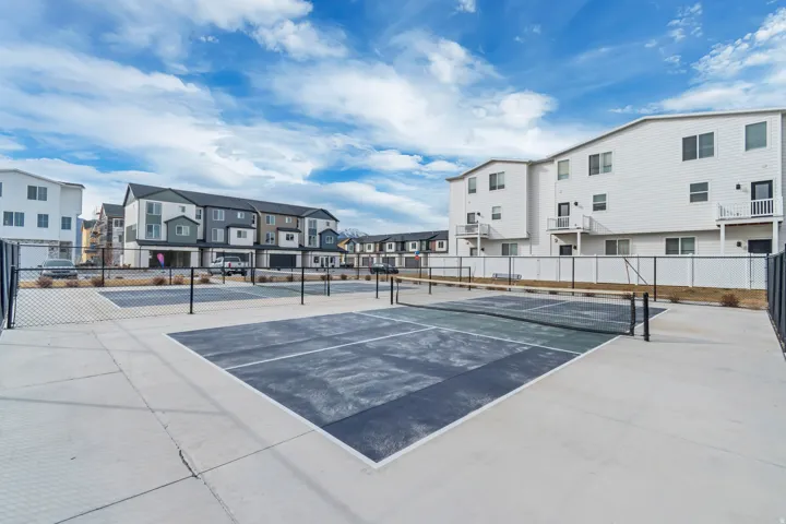 View of tennis court with a residential view.