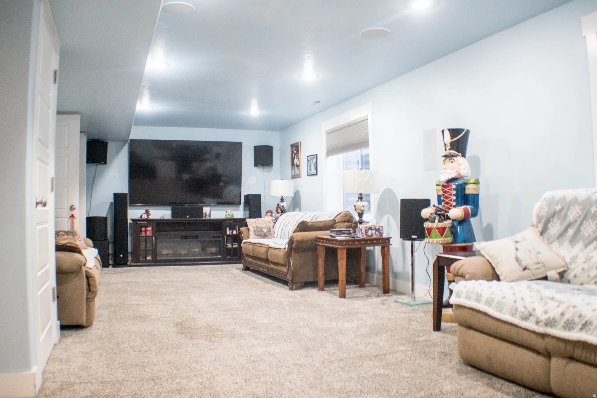 Spacious recreation room featuring carpet flooring, recessed ceiling lighting, a built-in media console, a wall-mounted television, and white trim