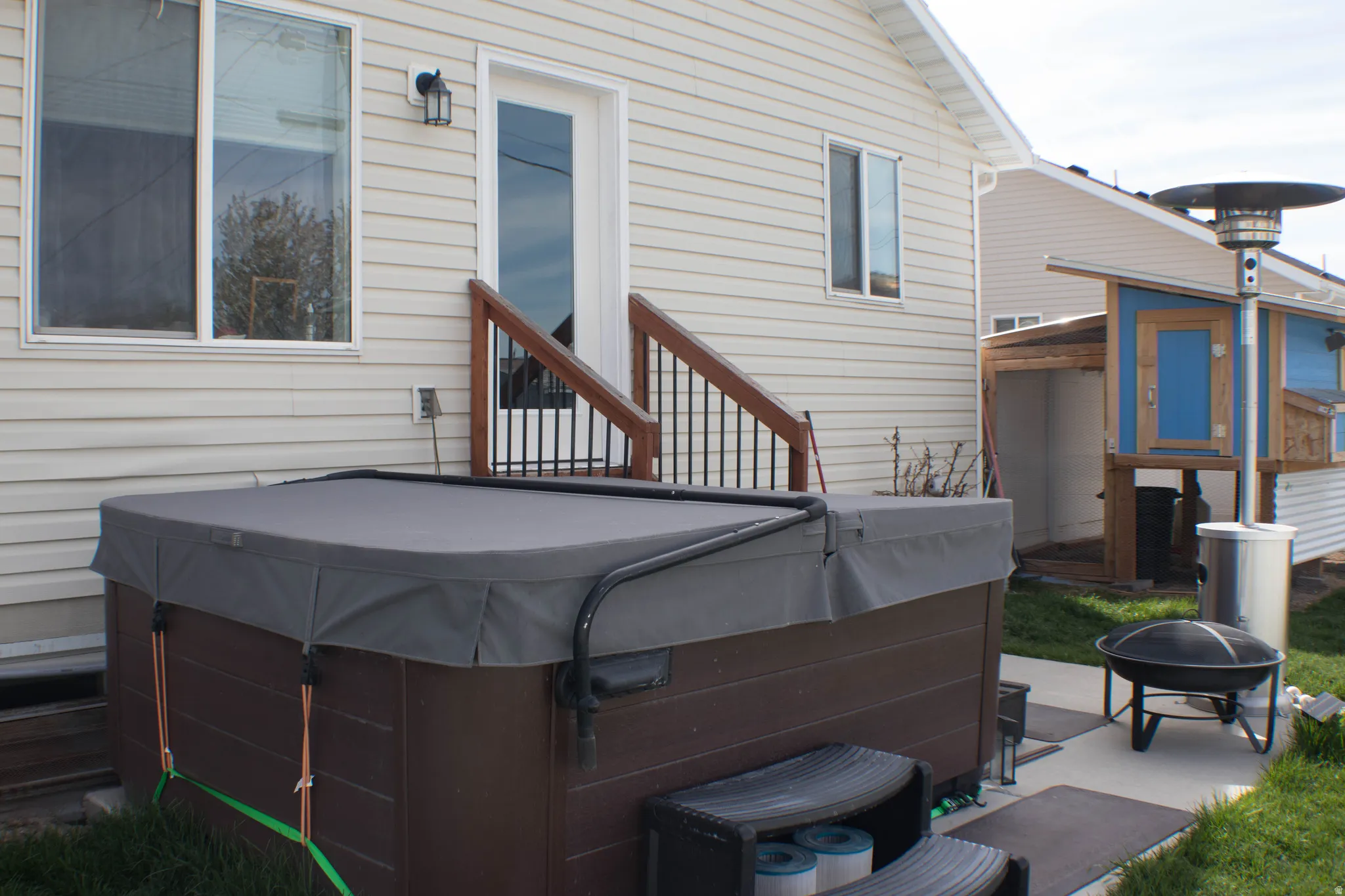 Rear view of house featuring a patio, a hot tub, and an outdoor fire pit