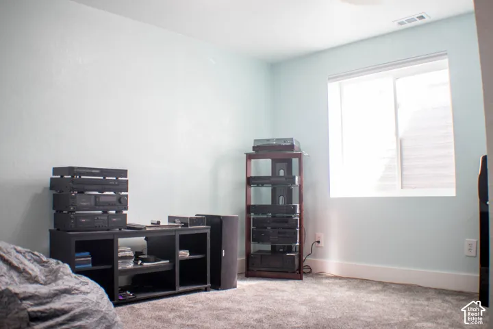 Bedroom with light colored carpet and baseboards