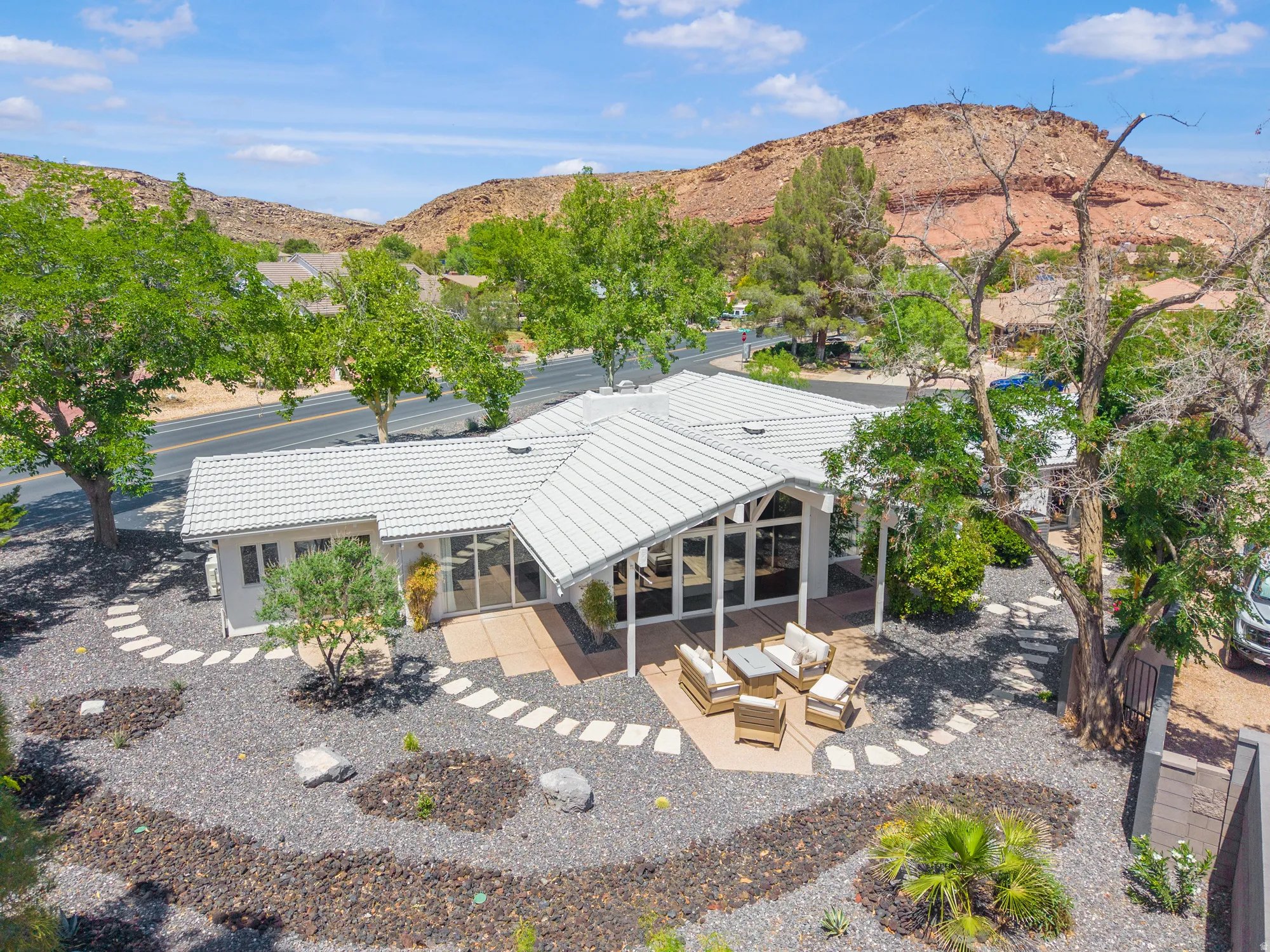 Back of property featuring a mountain view, a patio area, a tile roof, outdoor seating, and stucco siding