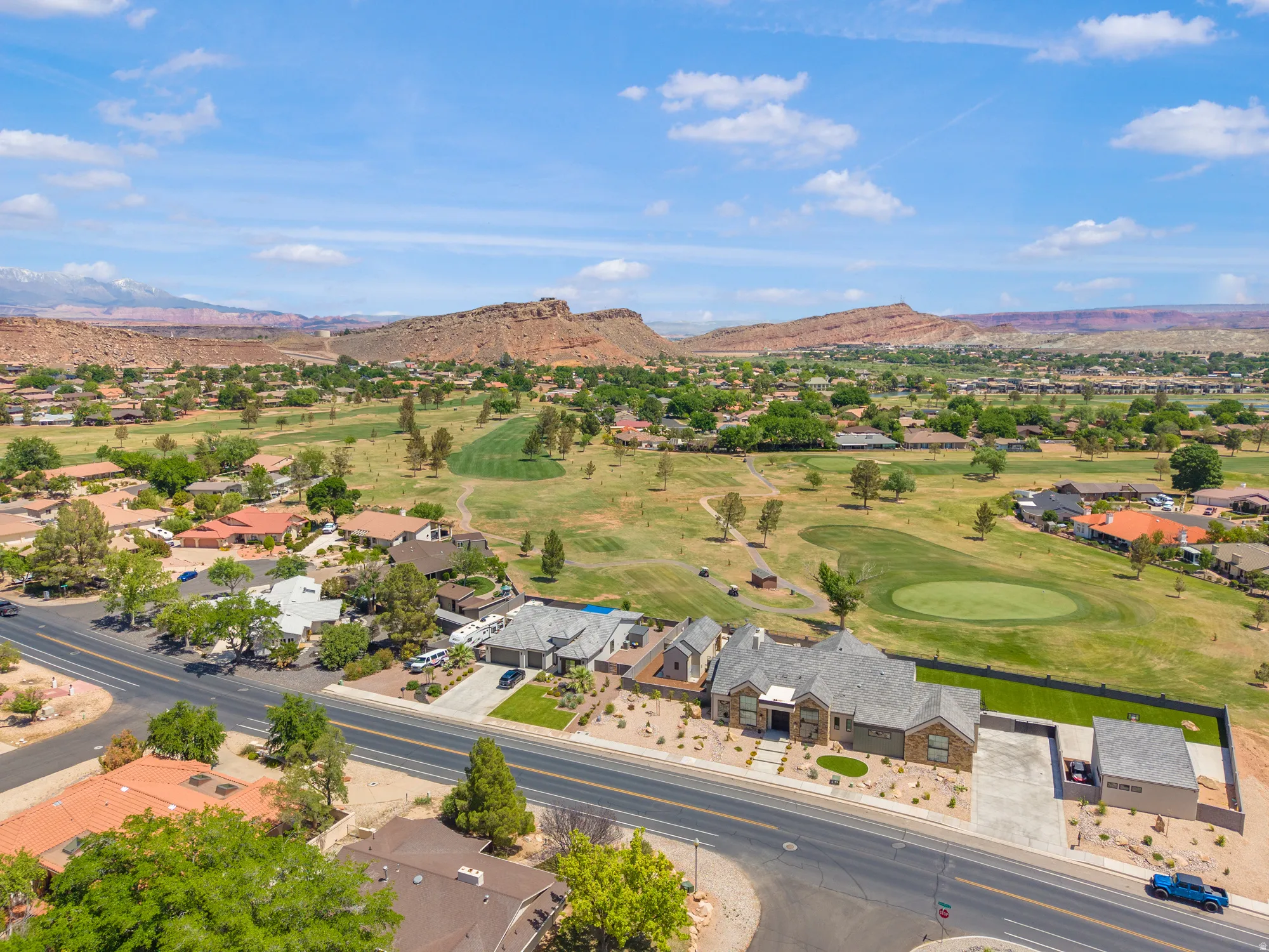 Aerial view of residential area with a golf course and a mountainous background