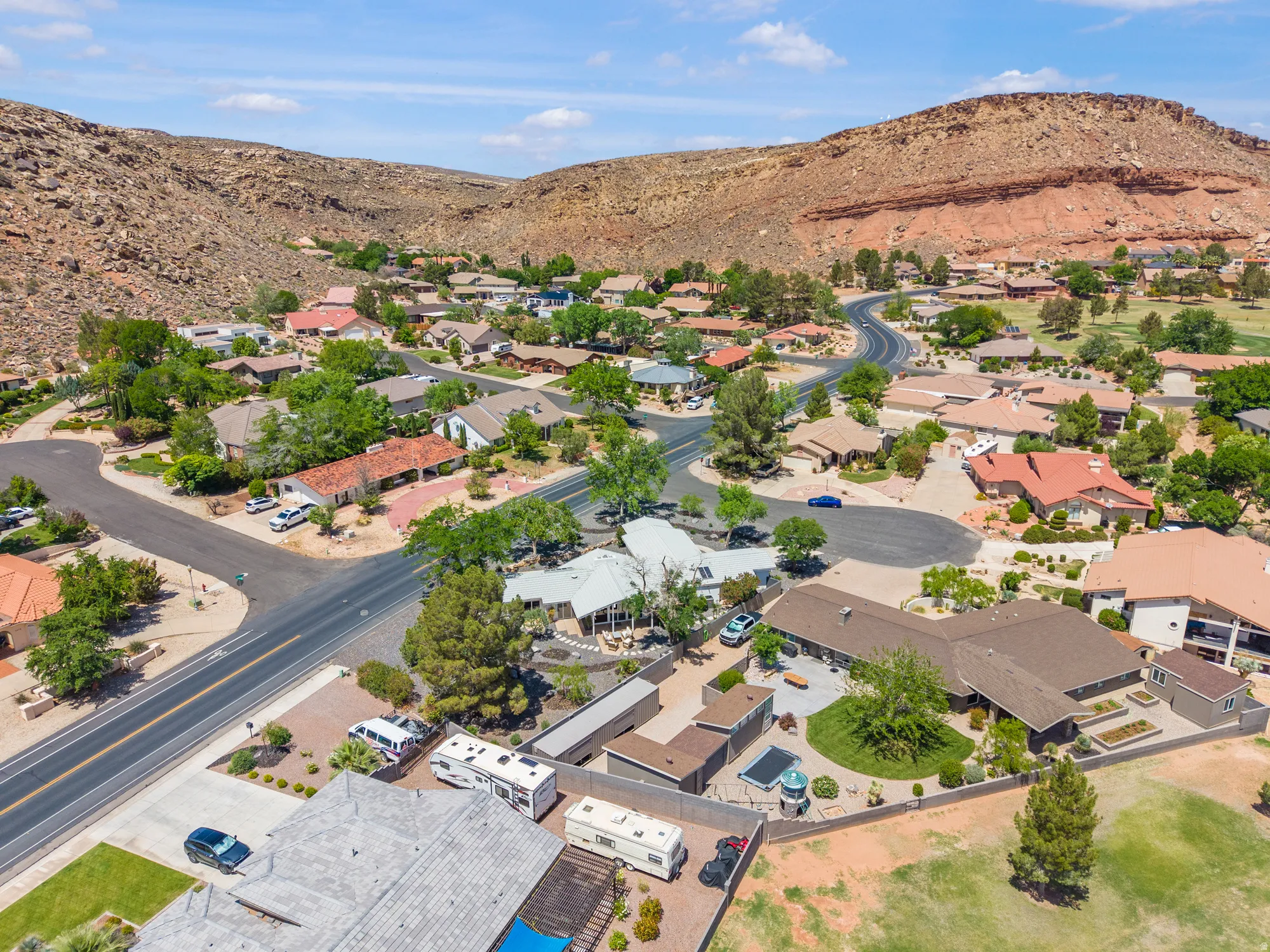 Aerial view of property and surrounding area featuring a mountain backdrop and nearby suburban area