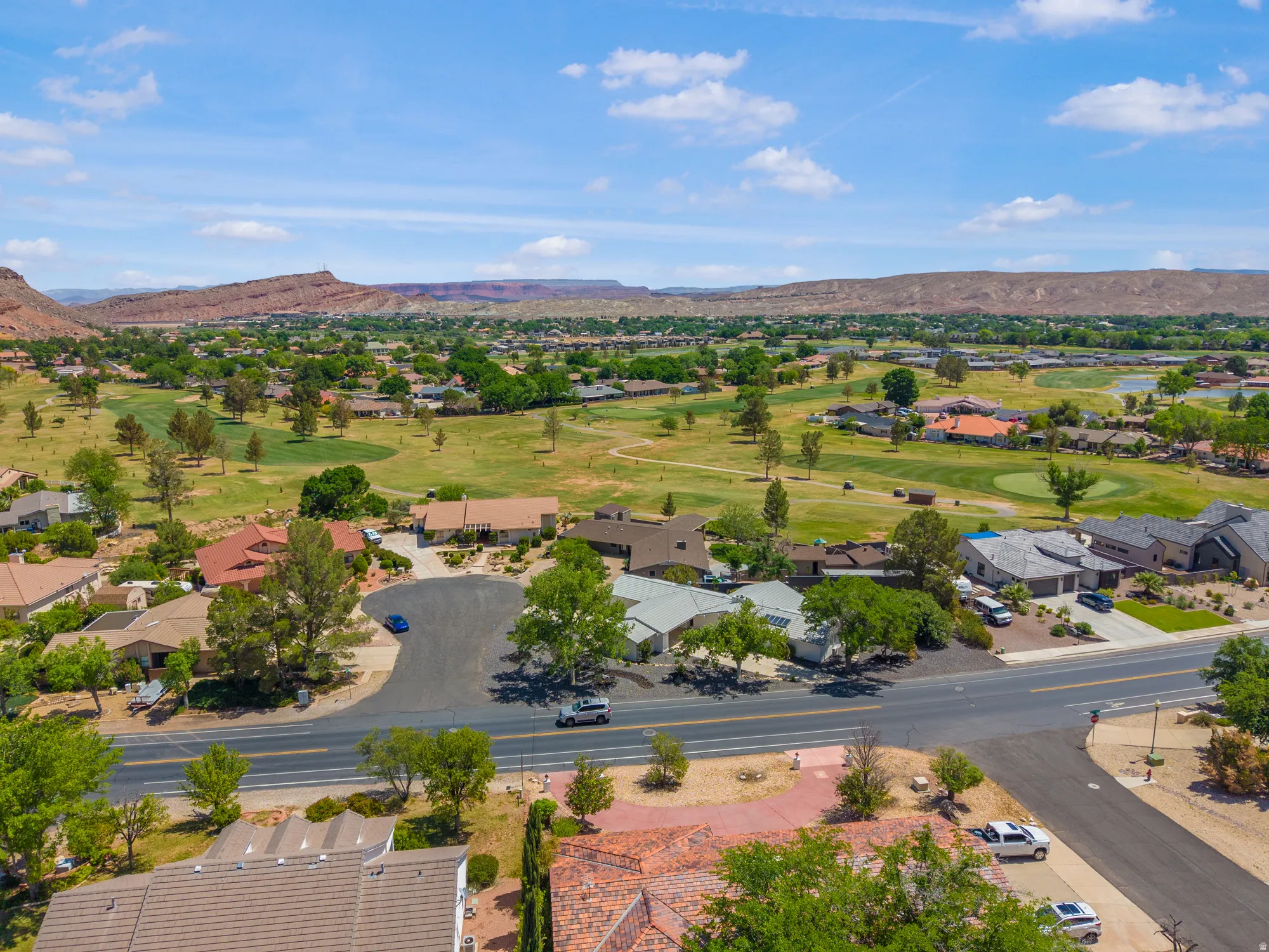 Aerial perspective of suburban area featuring mountains and a golf club