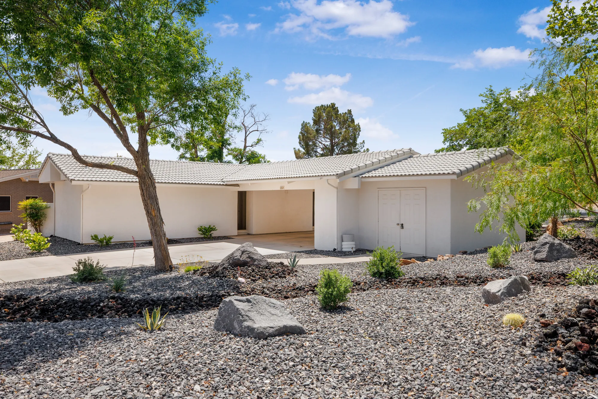 Ranch-style house featuring stucco siding and a tiled roof
