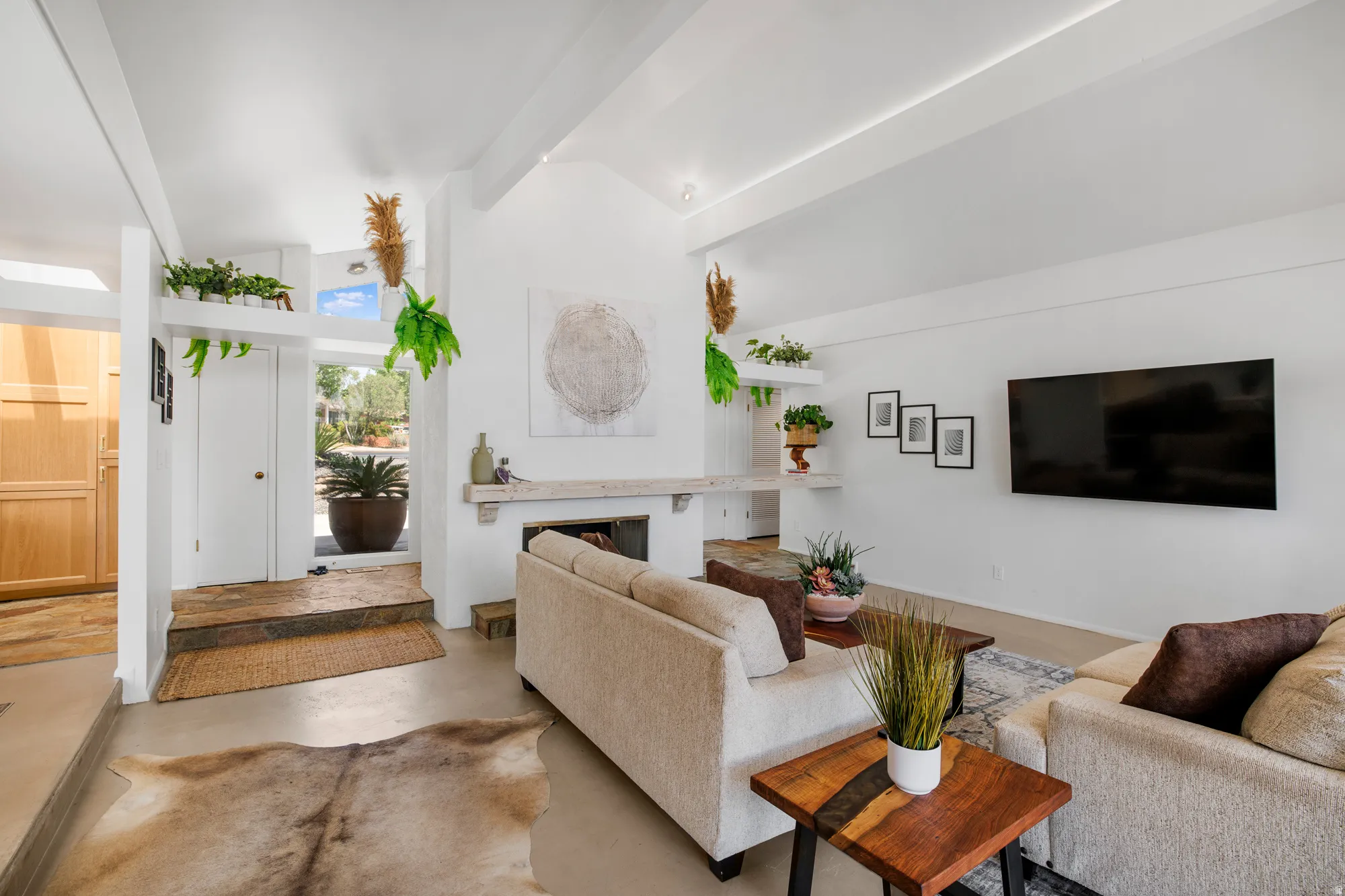 Living room with finished concrete flooring, a fireplace, and vaulted ceiling
