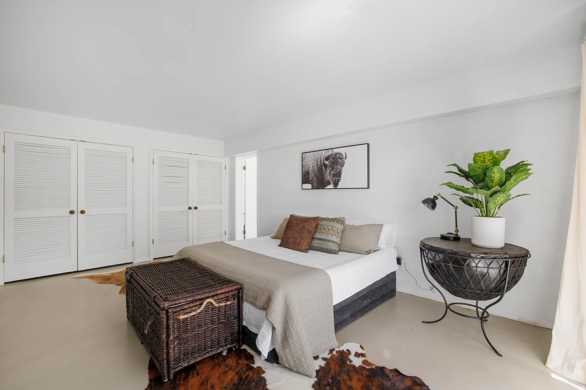 Bedroom with concrete flooring and multiple closets