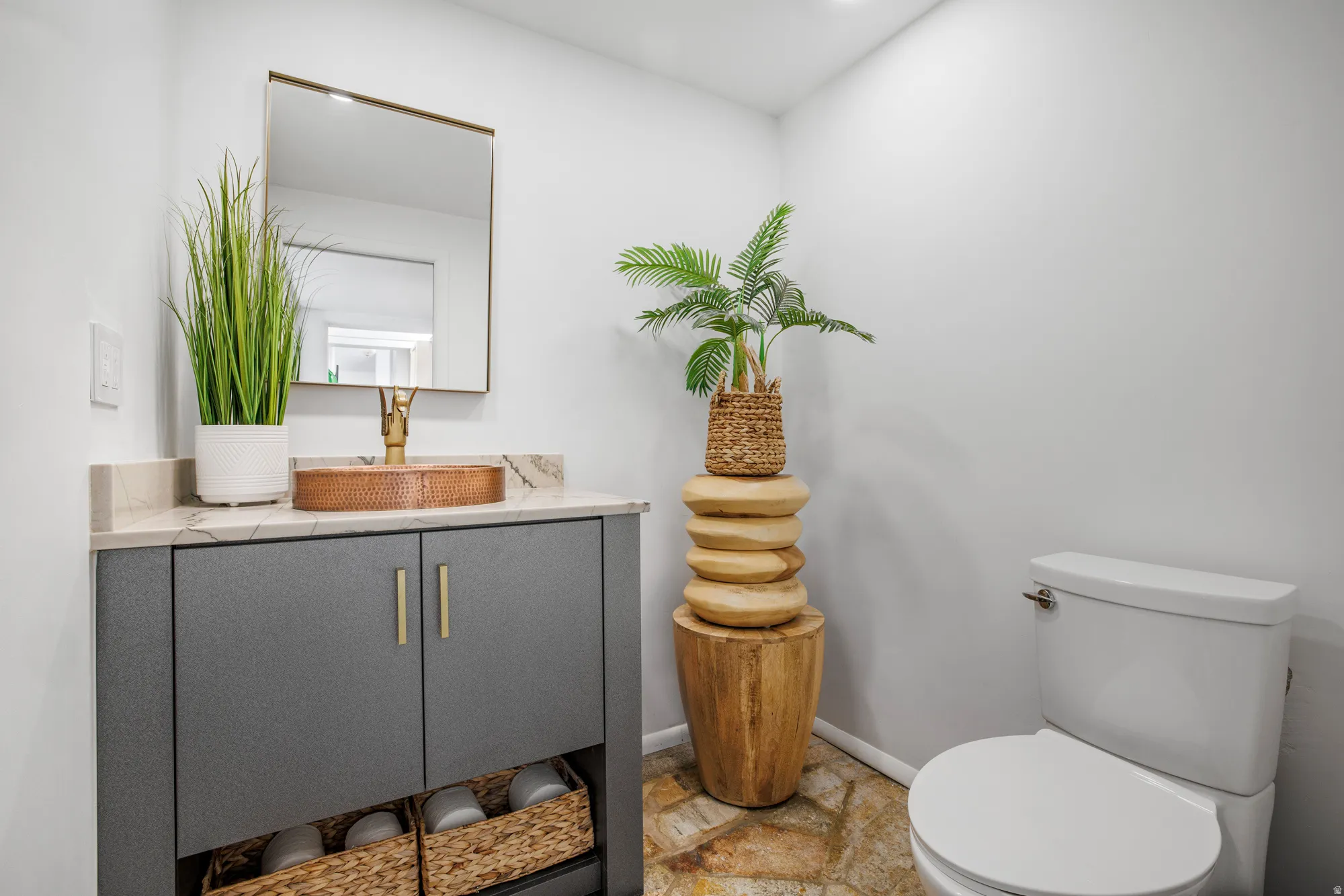 Bathroom featuring vanity and light stone finish floors